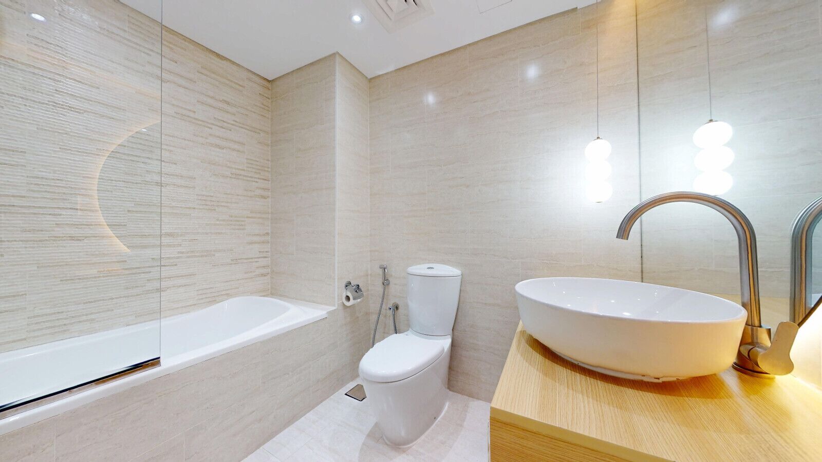 A modern bathroom with a bathtub, toilet, and large sink.