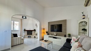 Una sala de estar moderna con chimenea, televisor de pantalla plana y sofá.