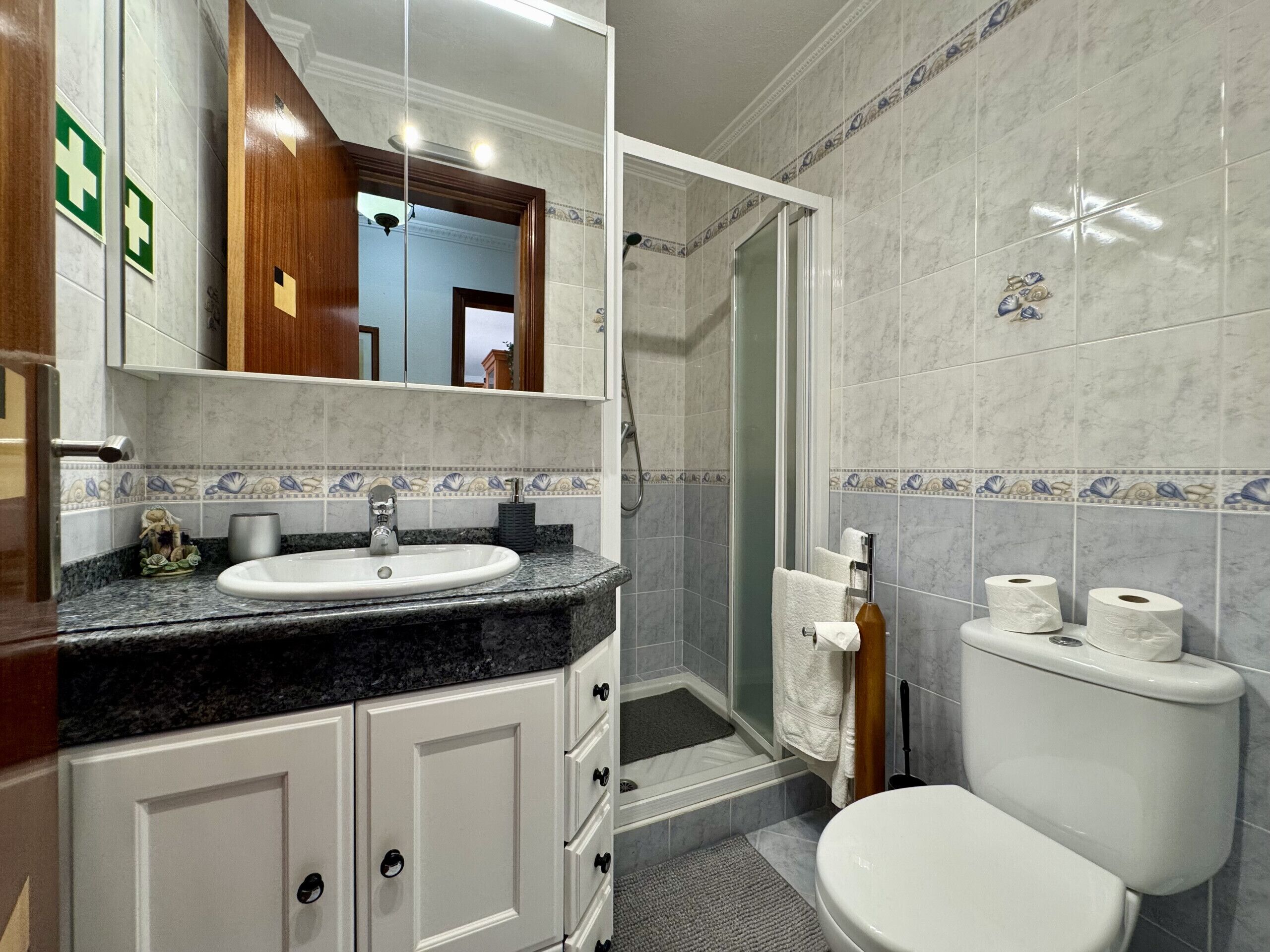 A bathroom with a sink, toilet, and shower area.