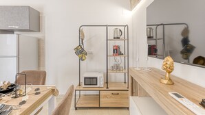 A modern kitchen with a microwave, coffee machine, and a wooden dining table.