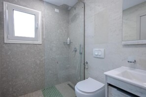 A bathroom with a shower, toilet, sink, and a window. - Beach Guesthouse (Durres)