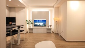 Un soggiorno moderno con una televisione a schermo piatto, un'area pranzo e un design minimalista.