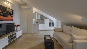 Un salon moderne avec un téléviseur à écran plat, un canapé et une table basse.