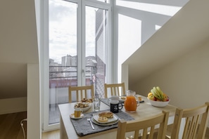 A dining table with breakfast items, a pitcher of orange juice, and a bowl of fruit. - NOVARA, 6 - In the attic with style (Milan)