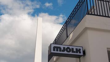 En bygning med et skilt, der viser teksten 'MJOLK' på facaden.
