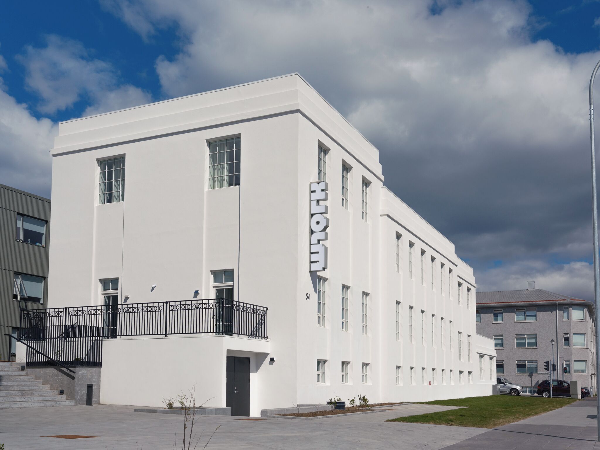 A white building with a large 'HOTEL' sign, a staircase, and a flat roof.