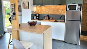 A modern kitchen with a built-in microwave, stainless steel appliances, and a wooden island with a bowl of fruit.