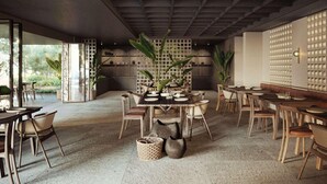Interior moderno de restaurante con mobiliario de madera, una mesa central para comer y vistas al exterior.