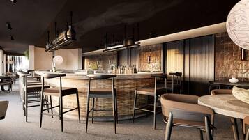 Un área de bar moderna con una isla central, taburetes y lámparas colgantes.