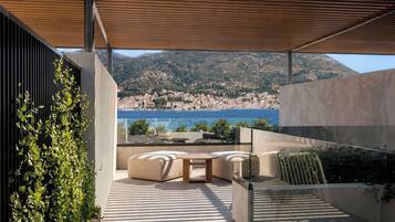 Un patio moderno al aire libre con vistas a un pueblo costero y montañas.