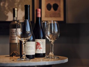 Varias botellas y copas de vino sobre una mesa de mármol.