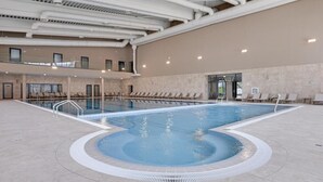 An indoor swimming pool with a clear water area, a separate shallow area, and a lounge area with chairs. - Hotel Complex SamElyon (Samokov)