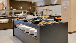 Una cocina moderna con un bufé, que incluye diversos alimentos y una estación de café.