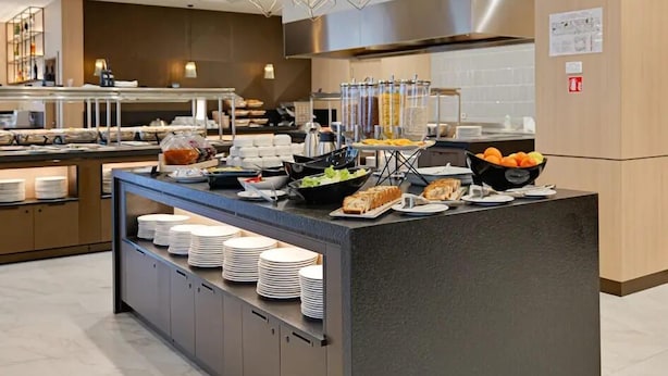 A modern kitchen with a buffet setup, including various food items and a coffee station. - Hotel Complex SamElyon (Samokov)