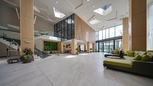 A spacious lobby with a high ceiling, a staircase, and a seating area with a sofa. - Hotel Complex SamElyon (Samokov)