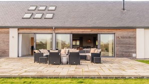 A modern house with a patio, outdoor seating, and skylights. - Luxury Cotswolds Estate with Pool (Wootton)