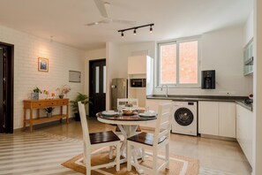 Una cucina moderna con zona pranzo, lavatrice e ventilatore a soffitto.