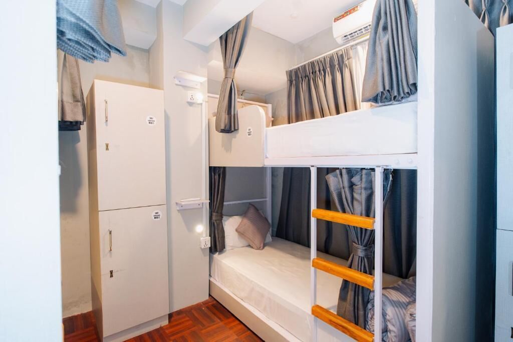 A compact room with bunk beds, a wardrobe, and a small kitchenette.