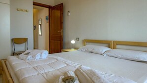 Ein Hotelzimmer mit einem großen Bett, einem hölzernen Kopfteil, einem Nachttisch mit Lampe und einem Sessel.