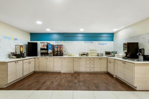 Una cocina moderna con una isla central, equipada con cafetera, microondas y tostadora.