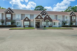 A multi-story residential building with a symmetrical facade, large windows, and a central entrance.