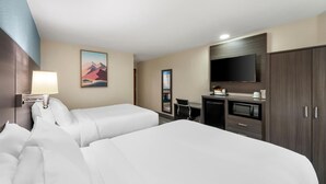 A hotel room with two beds, a desk with a microwave, a television, and a painting on the wall. - Sonesta Essential Hotels Longview (Longview)