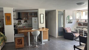 Une cuisine moderne avec un coin repas, un canapé et une bibliothèque.