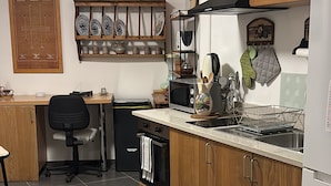 Une cuisine moderne avec des meubles en bois, un four à micro-ondes encastré et un évier en acier inoxydable.