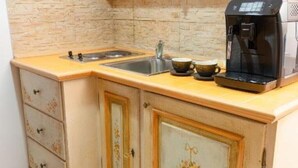 A kitchen with a coffee maker, two cups, and a sink. - Apartament 8 (Timișoara)
