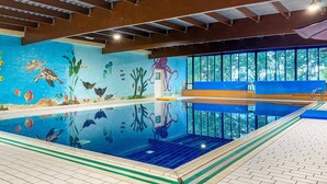 An indoor swimming pool with a mural of sea life, wooden beams on the ceiling, and a bench by the pool. - Elevated Ewijk Cottage for 6 (Ewijk)
