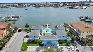 Un hôtel doté d’une piscine, offrant une vue sur le port de plaisance, et situé dans une rue bordée de voitures garées.