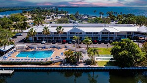 A hotel with a swimming pool, parking, and a view of the water. - Mangrove View 2BR - Pool Hot Tub Gym Access (Ruskin)