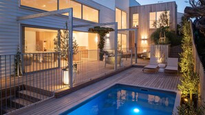 A modern house with a swimming pool, outdoor seating, and a patio area. - Bridgewater House Gas Heated Pool (Melbourne)