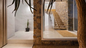 Ein modernes Interieur mit einer Steinwand, einer Treppe und einem Topfpflanze.