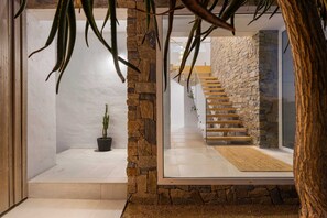 Ein modernes Interieur mit einer Steinwand, einer Treppe und einem Topfpflanze.