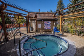 A hot tub area with a pool, surrounded by a fence and trees. - Lake Forest Glen #142 by Hauserman Rentals (Tahoe City)