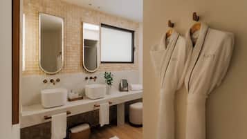 Une salle de bain moderne avec un grand miroir, deux lavabos et un porte-peignoir.