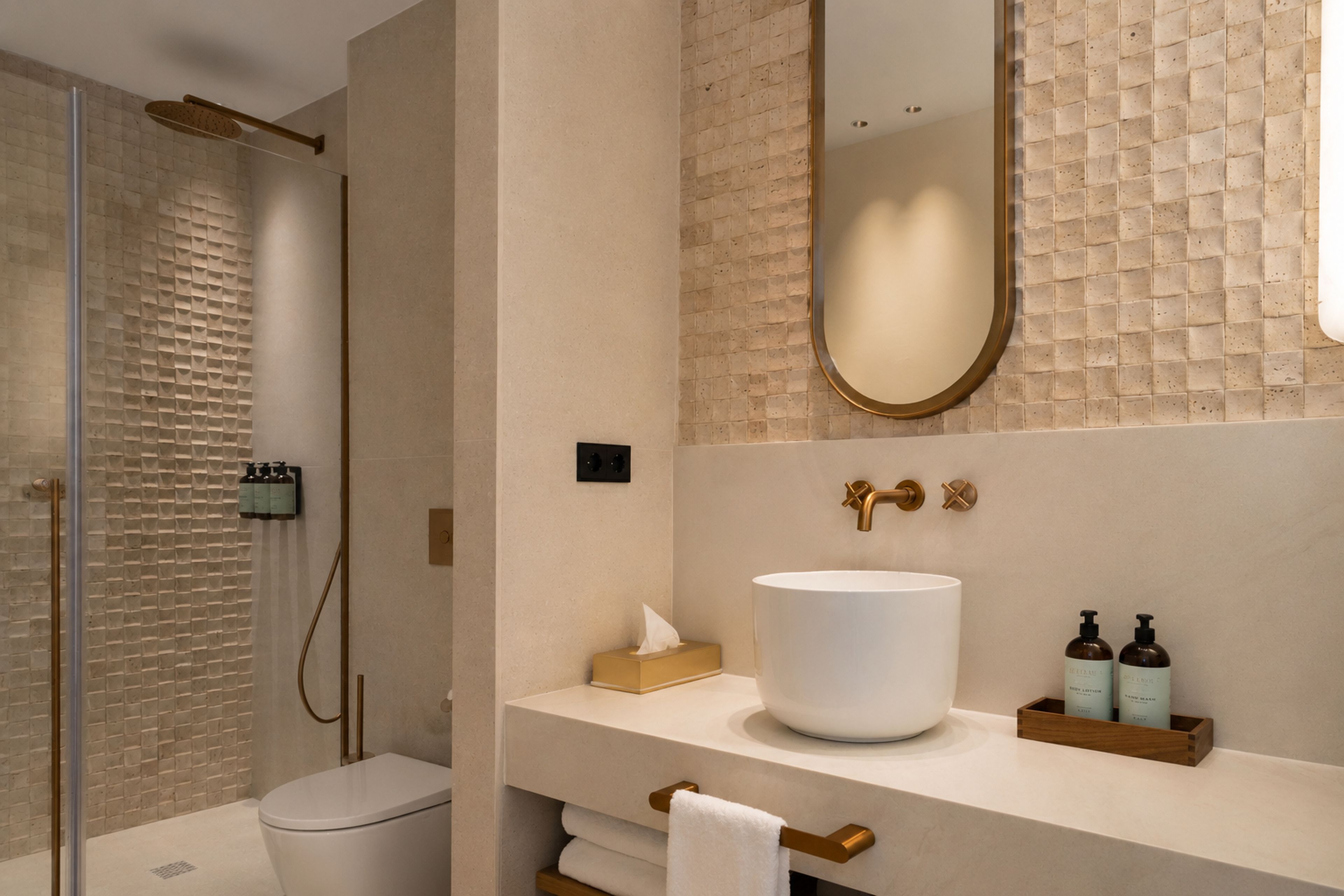A modern bathroom with a large mirror, a white sink, and a shower area.