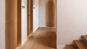 A hallway with wooden doors, a staircase, and a textured wall. - CASA METT Sitges - Adults Only (Sitges)