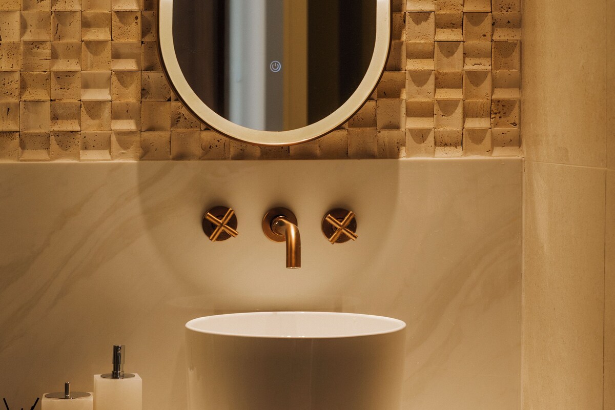 A bathroom with a white sink, a mirror, and a towel rack.