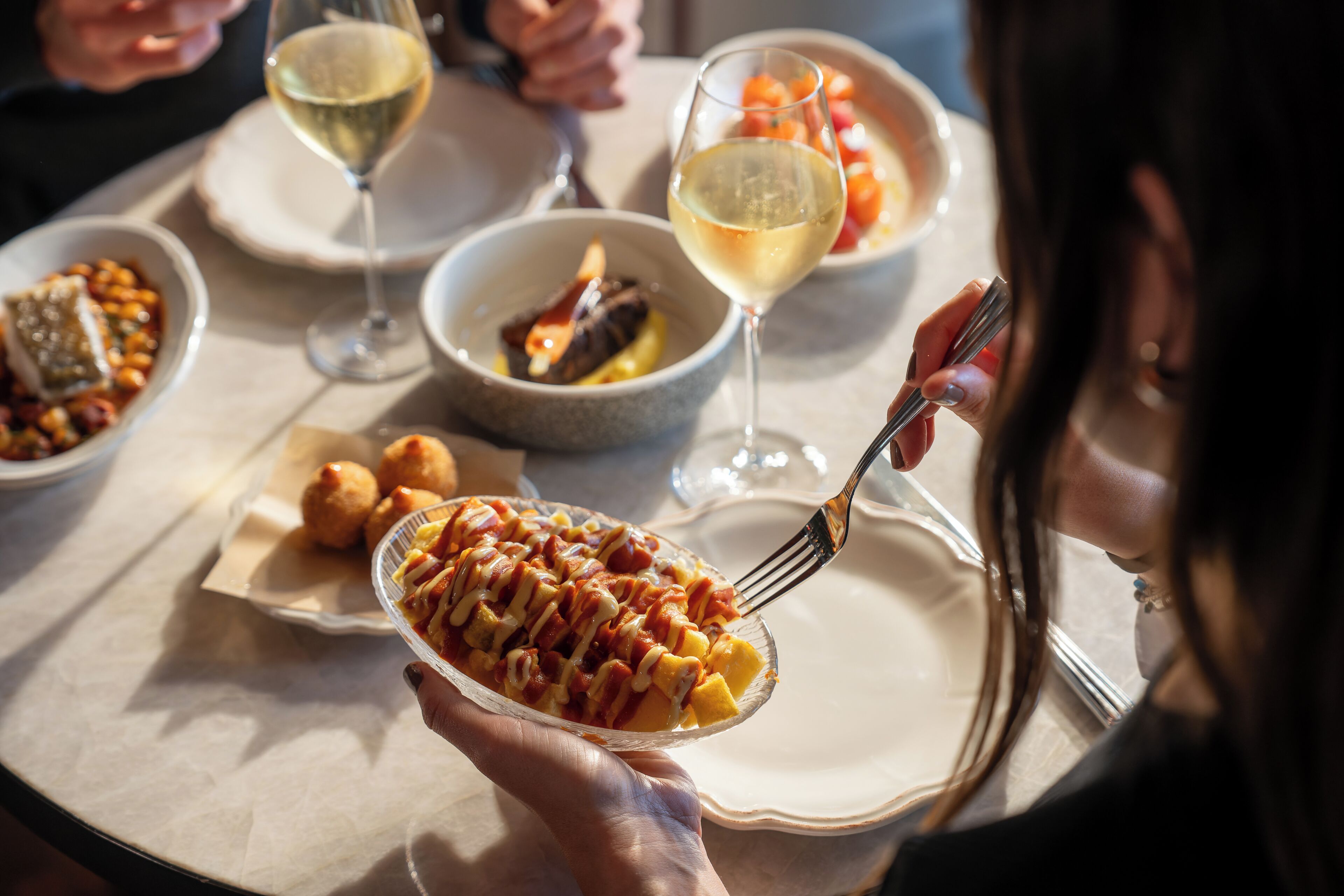 Una mesa de comedor con diferentes platos y copas de vino.