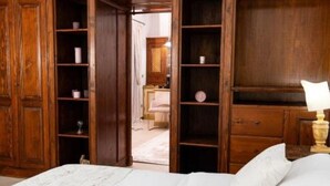 Une chambre à coucher avec un lit, une armoire en bois et des étagères.