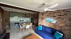 Um espaço de estar compacto com cozinha, sala de jantar e área de descanso.
