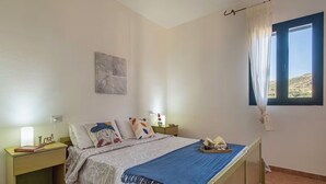 Una camera da letto con un letto, comodini, una finestra con tende e vista sull'esterno.