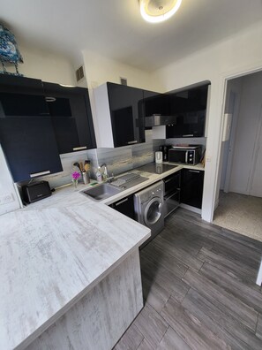 A modern kitchen with a built-in washing machine, a microwave, and a toaster. - Les flots bleus, waterfront, fantastic view of the bay, close to amenities (Villefranche-sur-Mer)