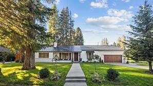 A single-story house with a front porch, a garage, and a well-maintained lawn. - Hayden Lake Home w/ Studio Suite & 2 Living Areas (Hayden Lake)