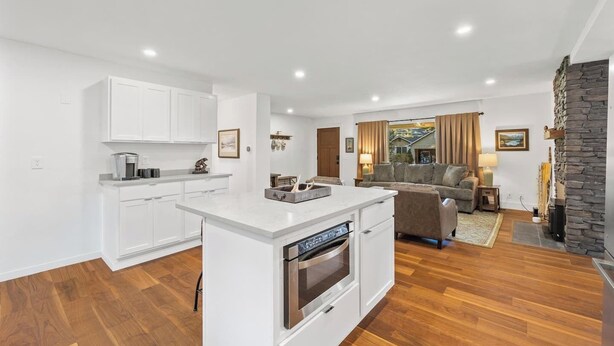 A modern kitchen with white cabinetry, a central island, and a built-in oven. - Hayden Lake Home w/ Studio Suite & 2 Living Areas (Hayden Lake)