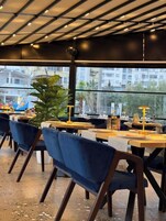 A restaurant with tables, chairs, and a large window overlooking a cityscape.