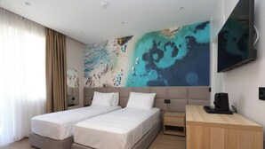 A hotel room with two beds, a TV, a desk, and a large wall mural. - Vila Lira (Durres)