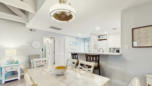 A modern kitchen with white cabinetry, a marble countertop, and a pendant light. - Palmetto Dunes Beach Villa | Golf, Pool,  Dogs OK (Hilton Head Island)